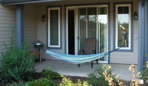 A comfortable summer hammock tied to 2 posts on the porch.